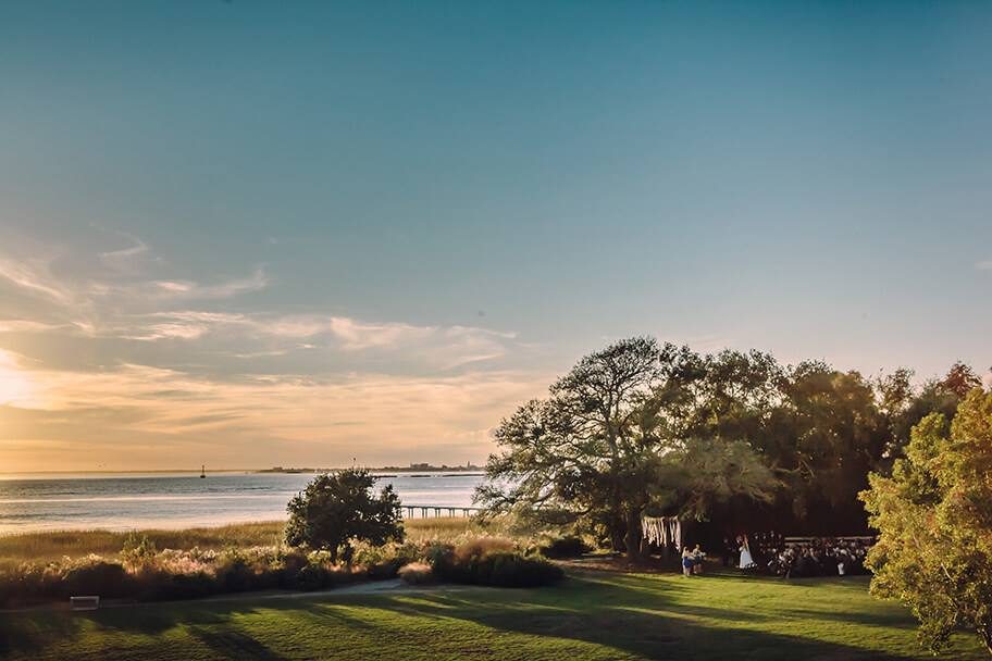 Sunset ceremony beneath the live oak at Alhambra Hall, Charleston Harbor in the background